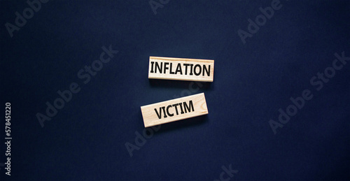 Inflation victim symbol. Concept words Inflation victim on wooden block. Beautiful black table black background. Business inflation victim concept. Copy space.