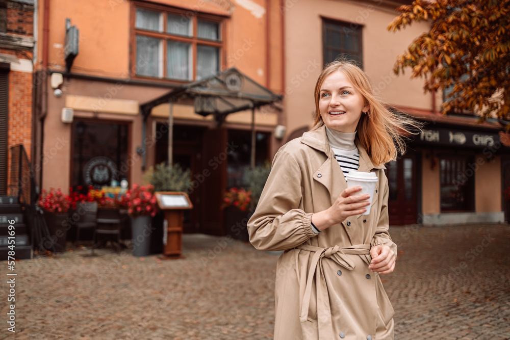 Portrait of happy nice woman drinks coffee while traveling in European old town enjoying cup of tea, coffee. Gdansk, Poland Portrait of happy nice woman drinks coffee while traveling in European old town enjoying cup of tea, coffee. Gdansk, Poland
