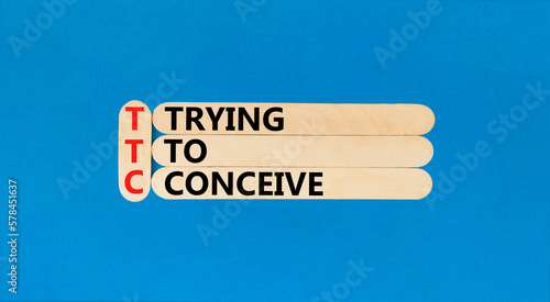 TTC trying to conceive symbol. Concept words TTC trying to conceive on wooden stick on a beautiful blue table blue background. Medical and TTC trying to conceive concept. Copy space.