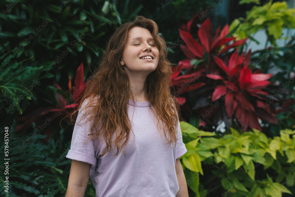 portrait of young girl on a green, natural background, eco friendly woman in a tropical park or jungle, positive lady enjoys walk at summer day portrait of young girl on a green, natural background, eco friendly woman in a tropical park or jungle, positive lady enjoys walk at summer day