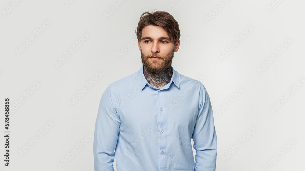 Handsome successful businessman guy with a tattoo around his neck in a fashion blue classic shirt on a white background in the studio Handsome successful businessman guy with a tattoo around his neck in a fashion blue classic shirt on a white background in the studio