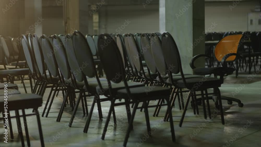 Rows of black chairs at empty convention hall center, side view, evening scene in an office building, slow motion. Remote working changed everyday routine. High quality 4k footage Rows of black chairs at empty convention hall center, side view, evening scene in an office building, slow motion. Remote working changed everyday routine. High quality 4k footage