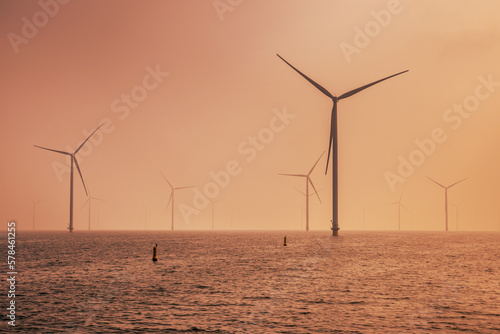 Offshore Wind farm at sea under cloudy sunset sky