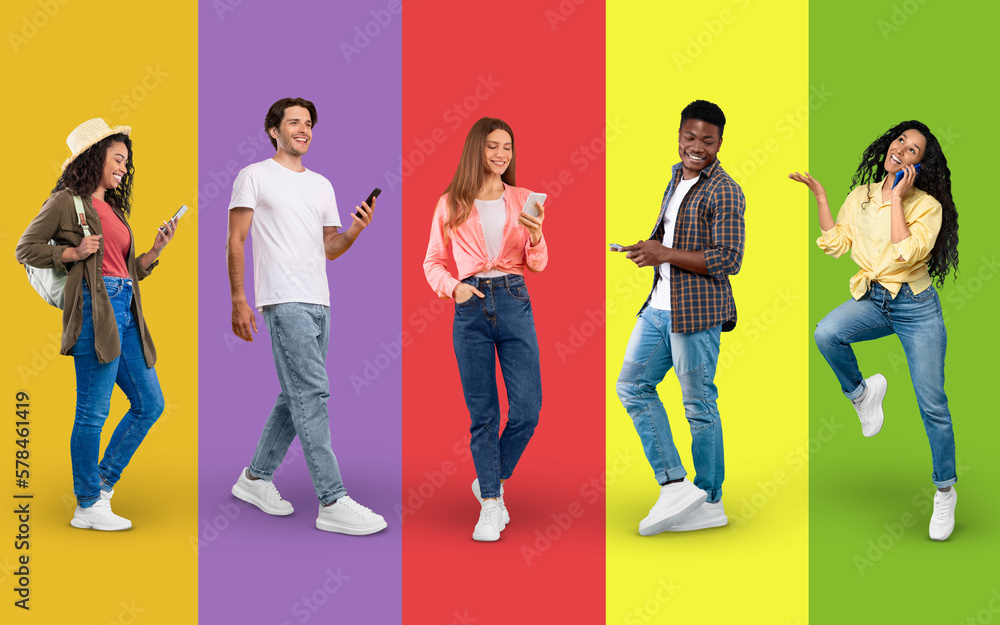 Obraz premium Happy young men and women using smartphones while walking over colorful backgrounds