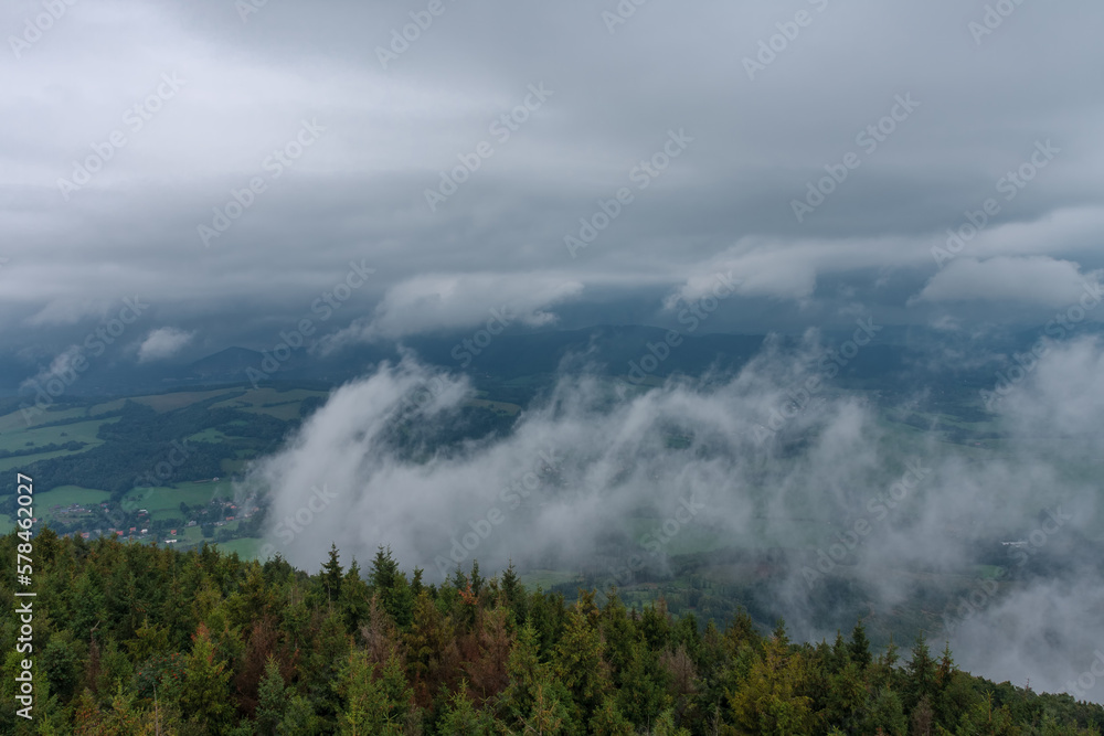 View from lookout tower Velky Javornik to Beskid Mountains in summer cloudy evening. The fog rises from the valley to the top View from lookout tower Velky Javornik to Beskid Mountains in summer cloudy evening. The fog rises from the valley to the top