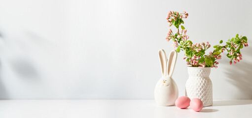Spring flowers in a vase and easter eggs on a light background. Easter background with copy space