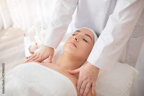 Closeup of beautiful woman enjoying body massage at modern wellness center