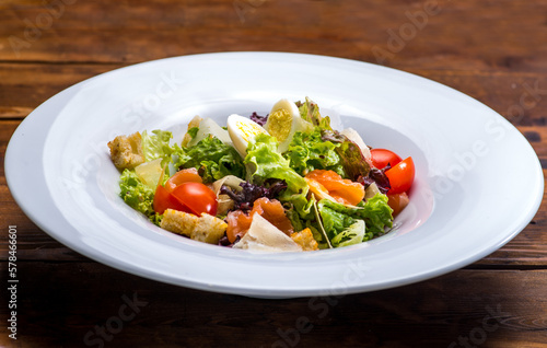 Salad with salmon and vegetables in a white plate