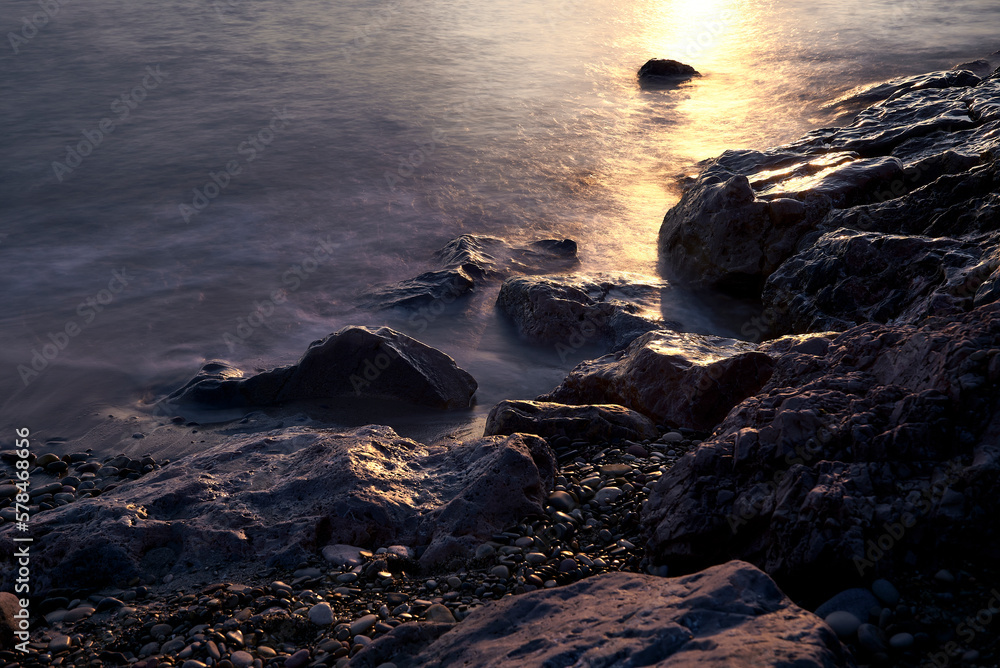 Obraz premium Line of stones from the coast at sunrise
