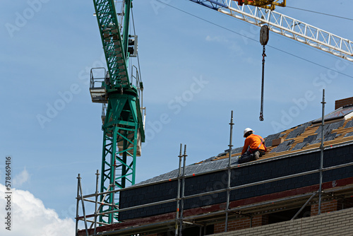 Obrero trabajando en el tejado de pizarra de un edificio en construcción.