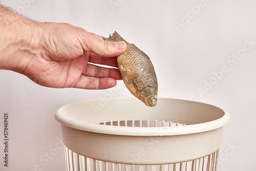 Принти на полотні Spoiled fish are thrown into the trash