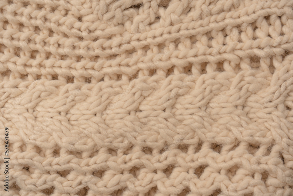 A fragment of beige knitted fabric, knitted from white sheep wool. A fragment of beige knitted fabric, knitted from white sheep wool.