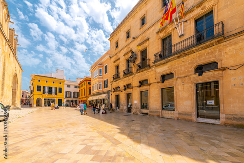 A colorful street of shops and cafes at the Ciutdadella Cathedral Plaza square in the medieval old town district of Ciutadella de Menorca, Spain. photo