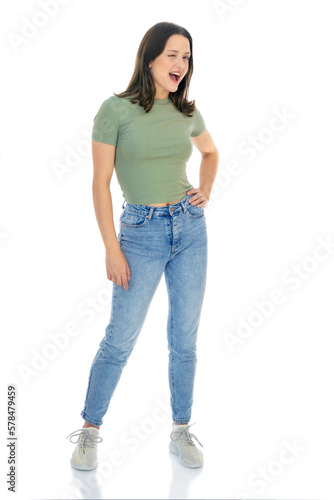 Full length portrait of sociable cheerful friendly girl winking into the camera. Beautiful young woman posing in studio isolated on white background. Flirting with you gesture.