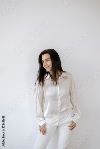 Dunkelhaarige Frau 35+, in weißem Hemd und weißer Hose