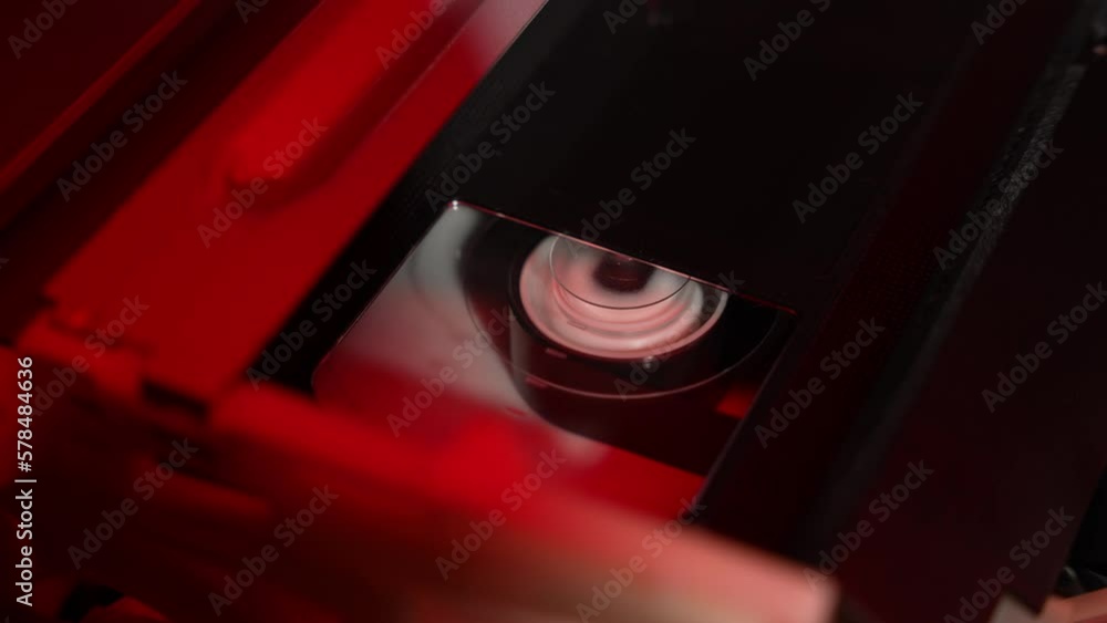 In a VCR, a cassette is being rewound, a fast-rewinding drum with film In a VCR, a cassette is being rewound, a fast-rewinding drum with film