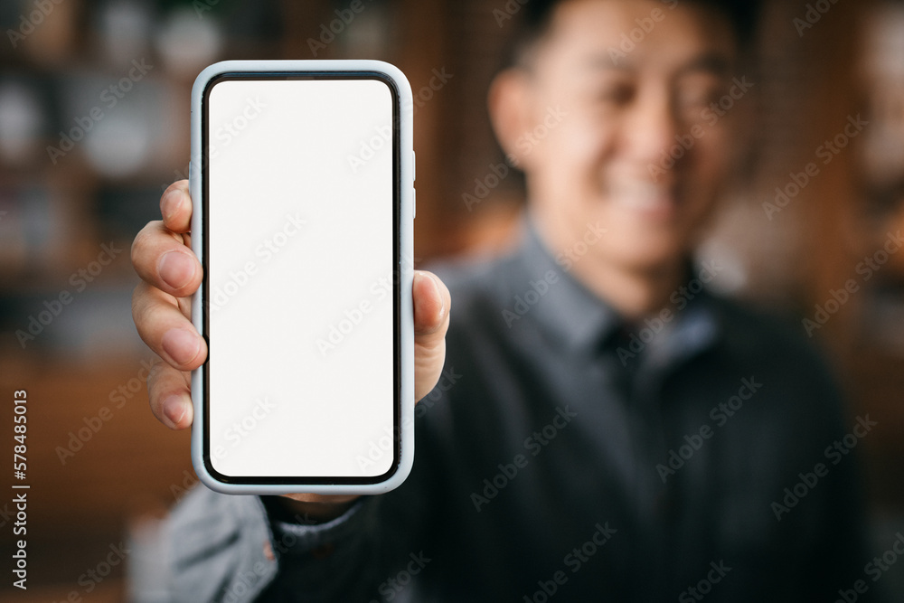Mobile Mockup. Smiling Asian Man Showing Big Blank Smartphone With White Screen Mobile Mockup. Smiling Asian Man Showing Big Blank Smartphone With White Screen