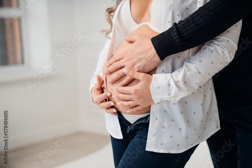 a man's hand on the stomach of a pregnant woman. 