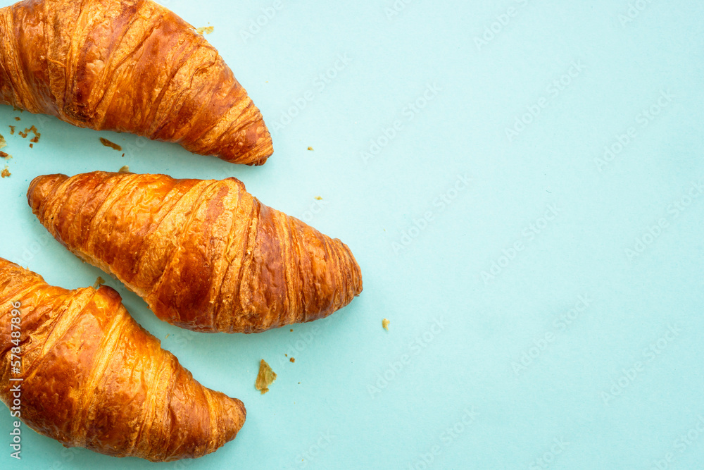 Croissant at blue background. French bakery. Flat lay image with copy space. Croissant at blue background. French bakery. Flat lay image with copy space.