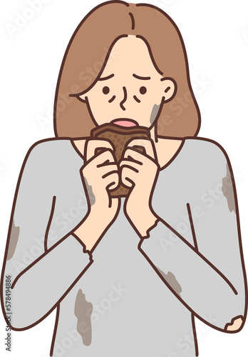 Tablou pe pânză Hungry woman in dirty torn Tshirt brings piece bread to mouth after long absence food
