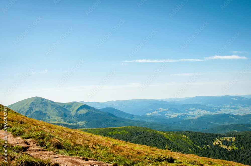 summer landscape, green peaks of mountain hills against the background of the morning blue sky