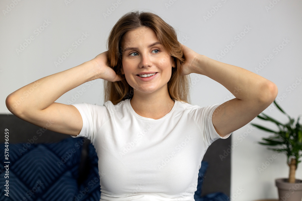 Portrait of beautiful woman looking away with happy smile and touching her hair. Attractive female with long hair enjoying quality of her hair at home. Beauty concept Portrait of beautiful woman looking away with happy smile and touching her hair. Attractive female with long hair enjoying quality of her hair at home. Beauty concept
