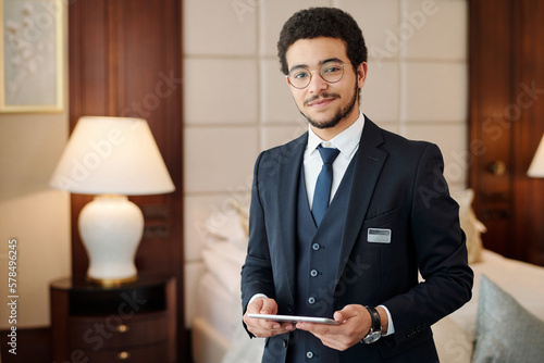 Obraz na płótnie Young confident head manager of luxurious hotel looking at camera while standing