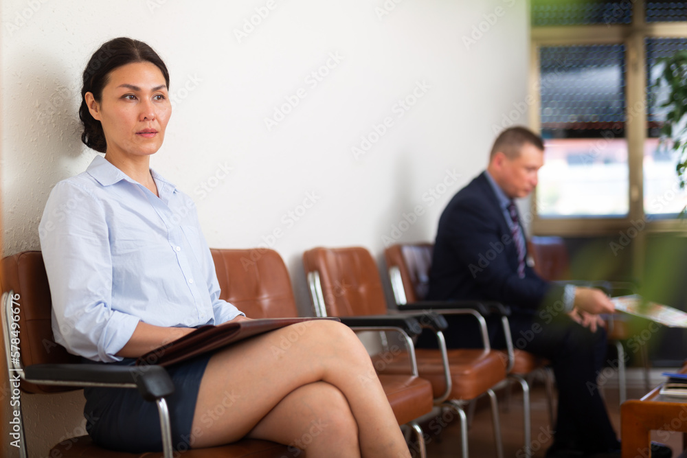 Fototapeta premium Portrait of confident asian woman with briefcase waiting for job interview while sitting at office lobby