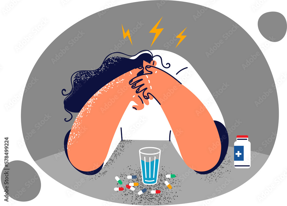 Woman sitting at table with pills suffering from headache or migraine due to overwork Woman sitting at table with pills suffering from headache or migraine due to overwork