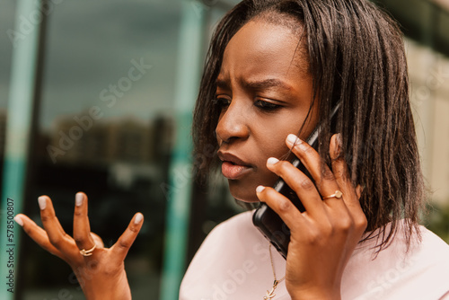 African american woman hold hand phone surfing internet chatting friends colleague call order taxi or food talking phone speaking outside street angry agressive emotional lady, conflict arguing

