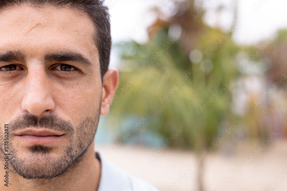 Portrait of happy biracial man looking at camera and smiling at beach, with copy space Portrait of happy biracial man looking at camera and smiling at beach, with copy space