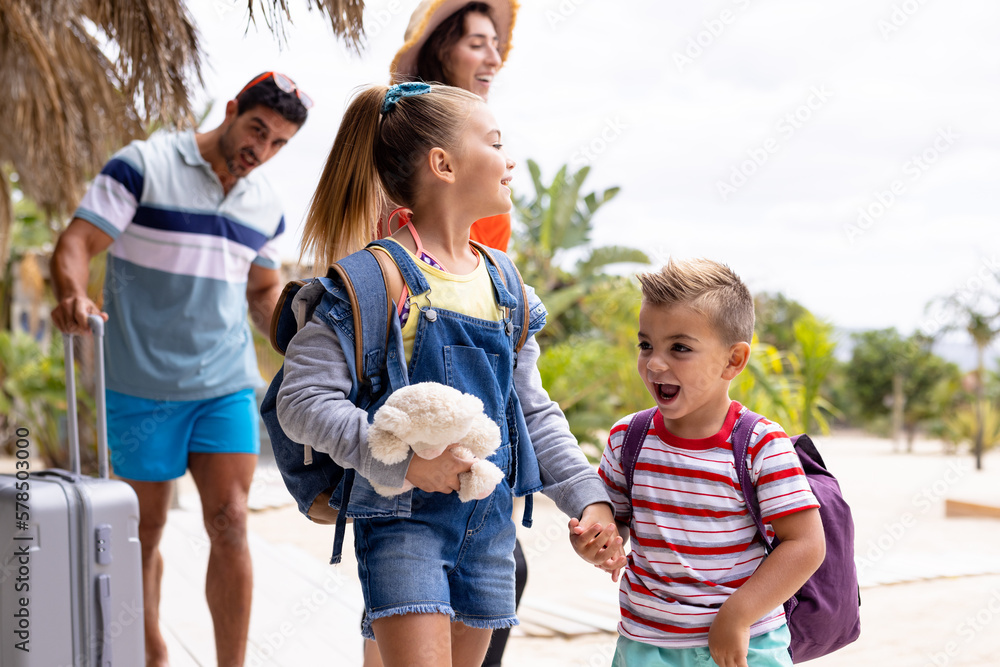 Happy biracial family walking at beach