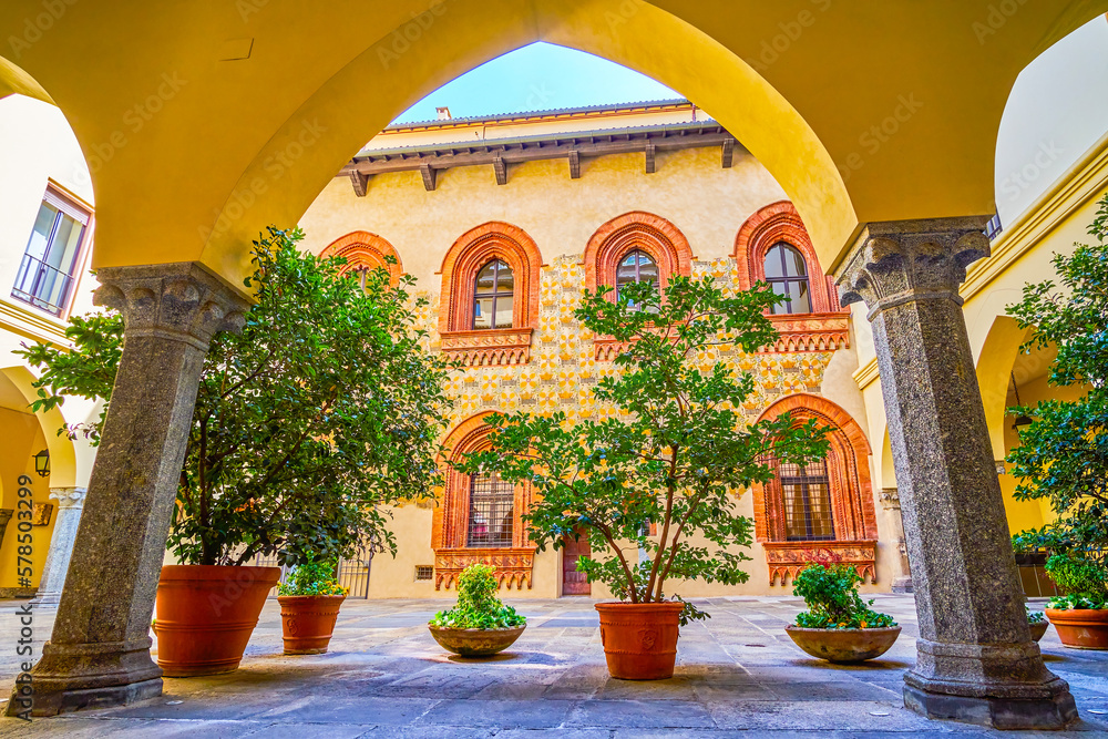 The view through the arcades of Palazzo Borromeo on the medieval frescoes on the inner wall of the palace, Milan, Italy
