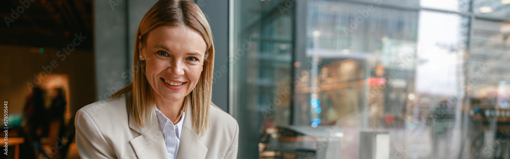 Attractive businesswoman having lunch and making notes while working in cafe sitting near window Attractive businesswoman having lunch and making notes while working in cafe sitting near window