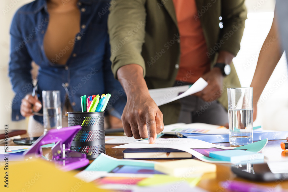 Midsection of diverse friends working together at home Midsection of diverse friends working together at home