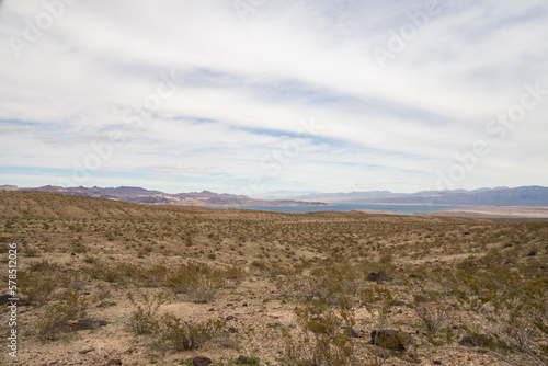 Desert landscape with mountain background and blue sky with white clouds