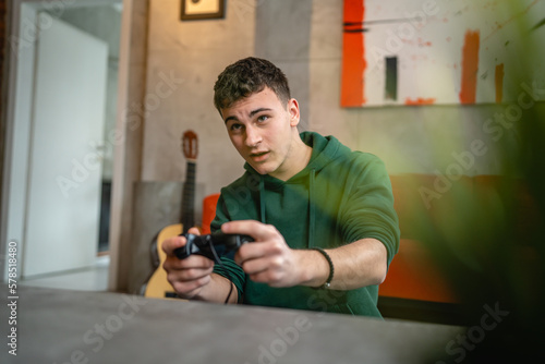 One teenager caucasian male young male play console video game at home