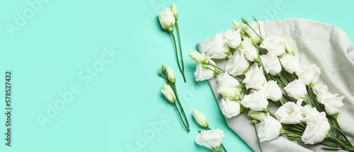 White eustoma flowers on turquoise background with space for text
