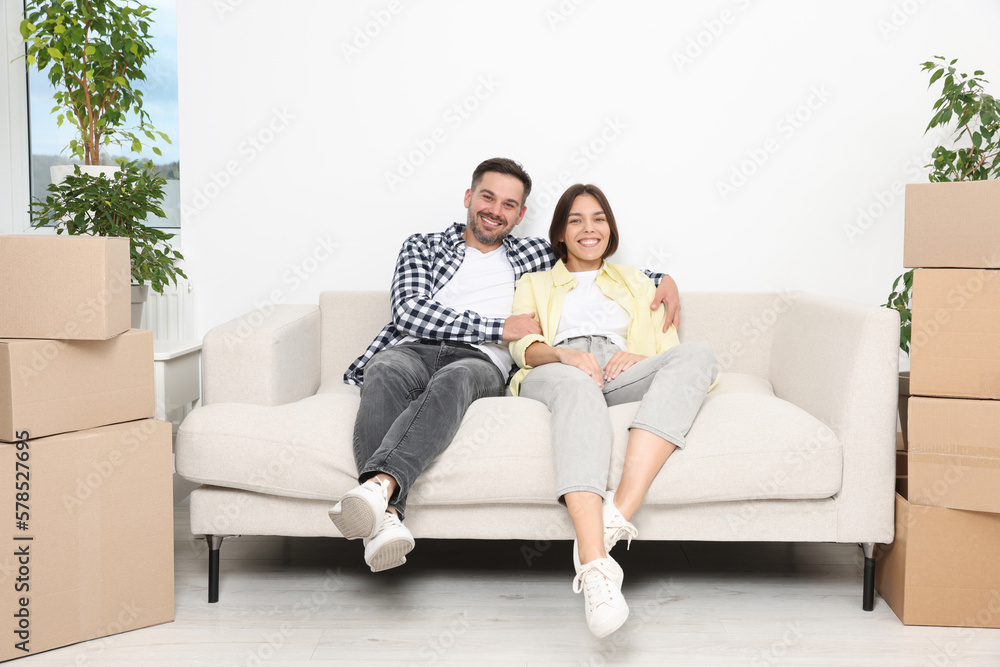 Happy couple resting on sofa in new apartment. Moving day