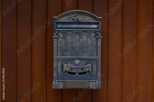 Metal letter box on wooden wall outdoors