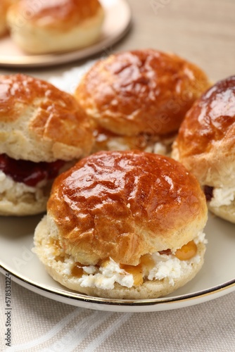 Freshly baked soda water scones with jam and butter on table, closeup