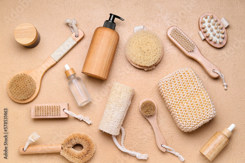 Set of massage brushes with bath sponge and cosmetic products on color background