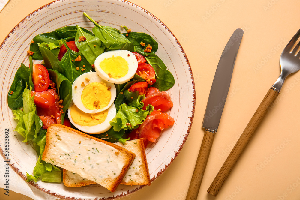 Plate of delicious salad with boiled eggs and salmon on beige background Plate of delicious salad with boiled eggs and salmon on beige background