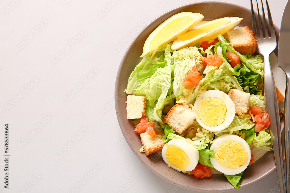 Plate of delicious salad with boiled eggs and salmon on grey background Plate of delicious salad with boiled eggs and salmon on grey background