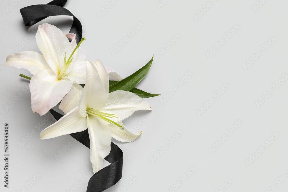 Black funeral ribbon and beautiful lily flowers on white background - obrazy, fototapety, plakaty 