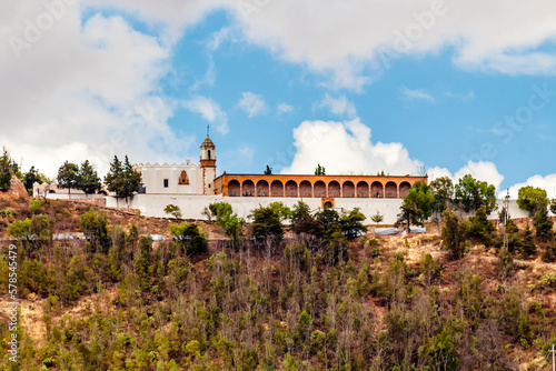 building in top of hill with blue sky and  white clouds  bufa hill in zacatecas 
