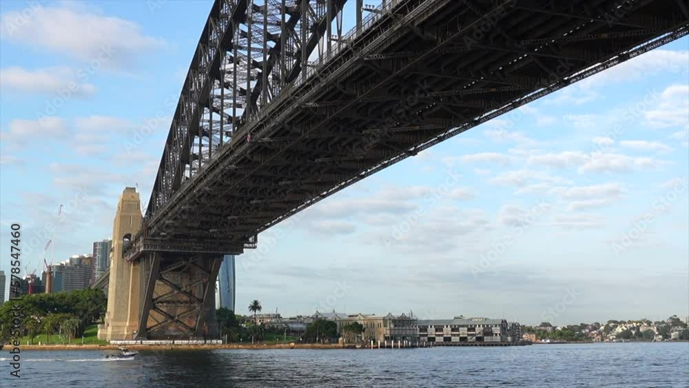 A small fast boat passes underneath the Sydney Harbour bridge in Australia A small fast boat passes underneath the Sydney Harbour bridge in Australia