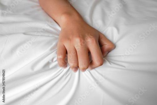 A photo of a man and woman's hands having sex on a bed. make love.