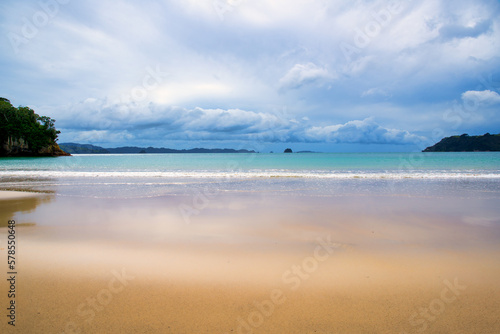 The beautiful golden sandy beach and clear blue water in the ocean in the bay