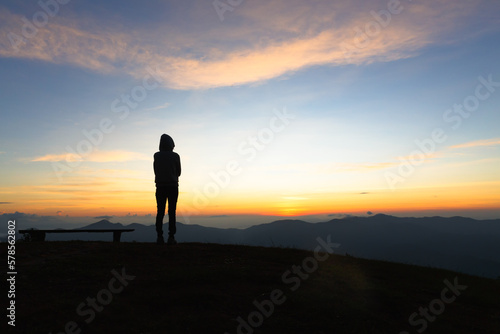 silhouette woman standing on mountain in morning and vintage filter, Feast hiking. Deep thought. Fall sunset.Person watch.Spring sun. Person watch sky miracles.